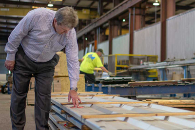 CEO Steve Browning inspects a stack of metal wall panels at the Vulcan Steel metal building manufacturing plant.