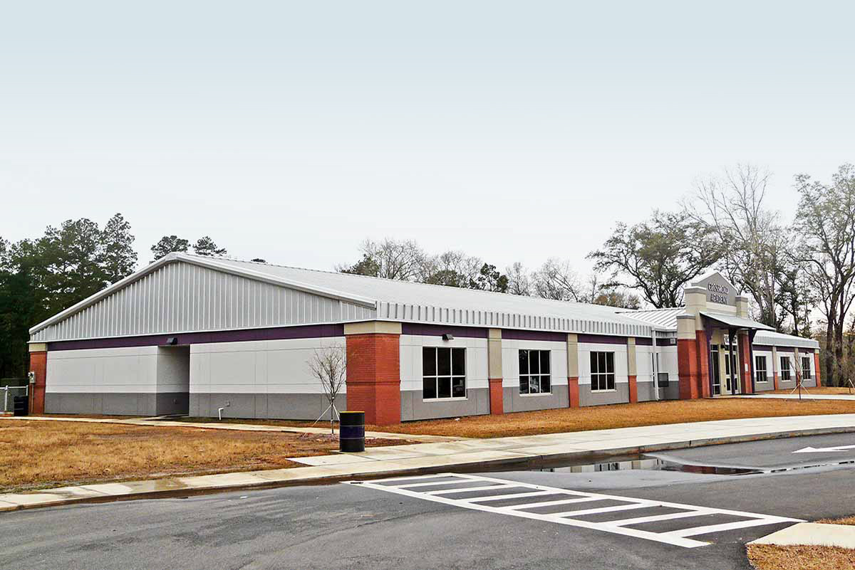 Crossroad Academy Charter School has brick corner accents and a band of purple encircling the metal building’s exterior.